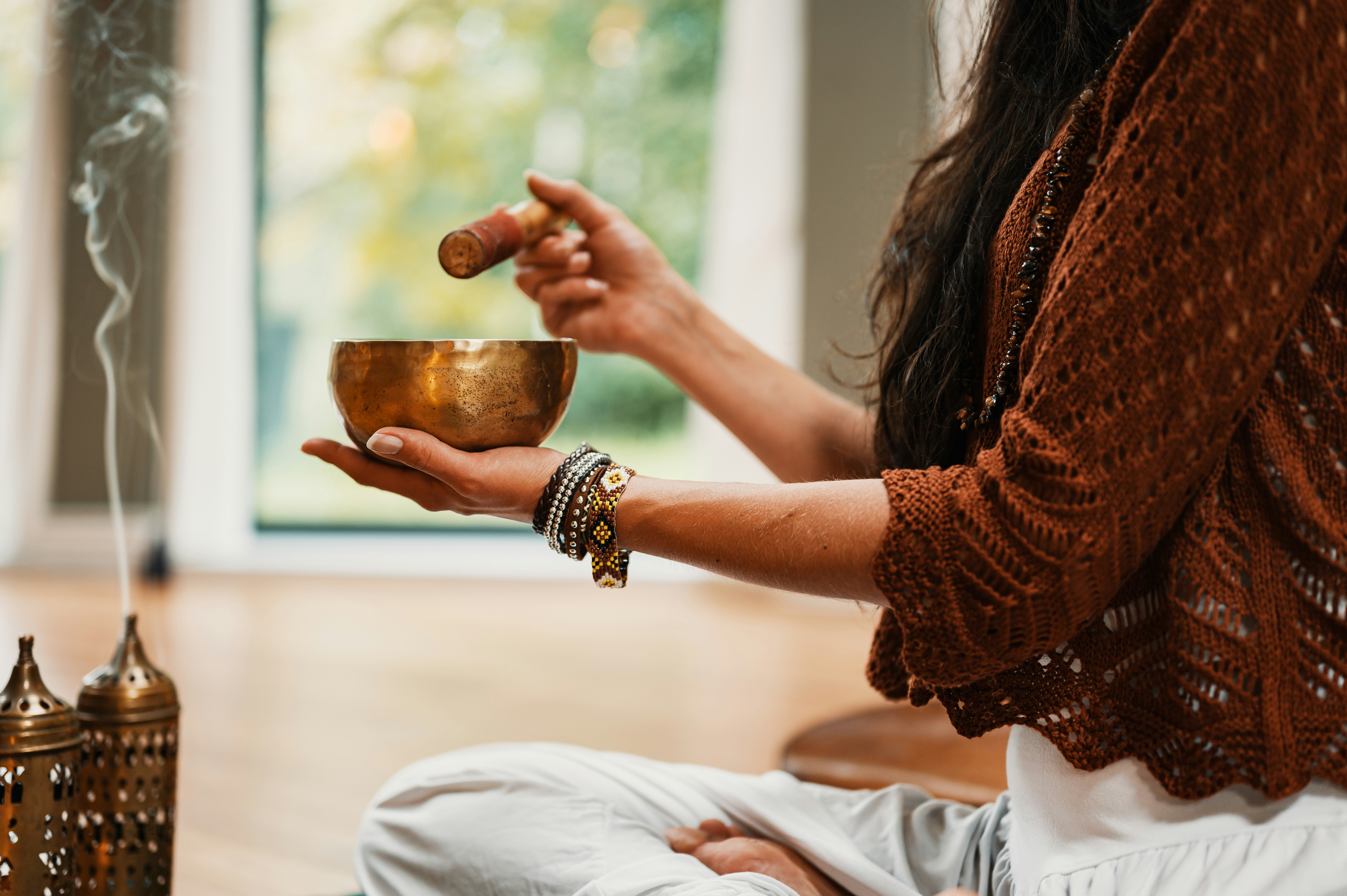 Woman with singing bowl and incense in meditation