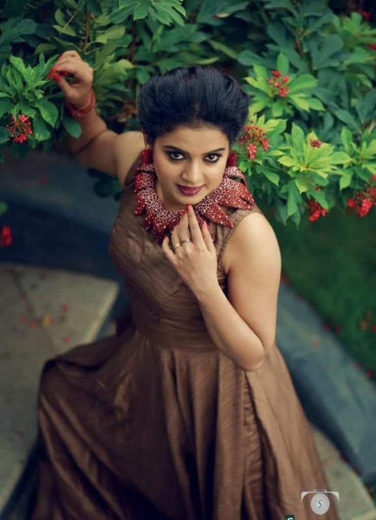 Model in rust dress with statement necklace