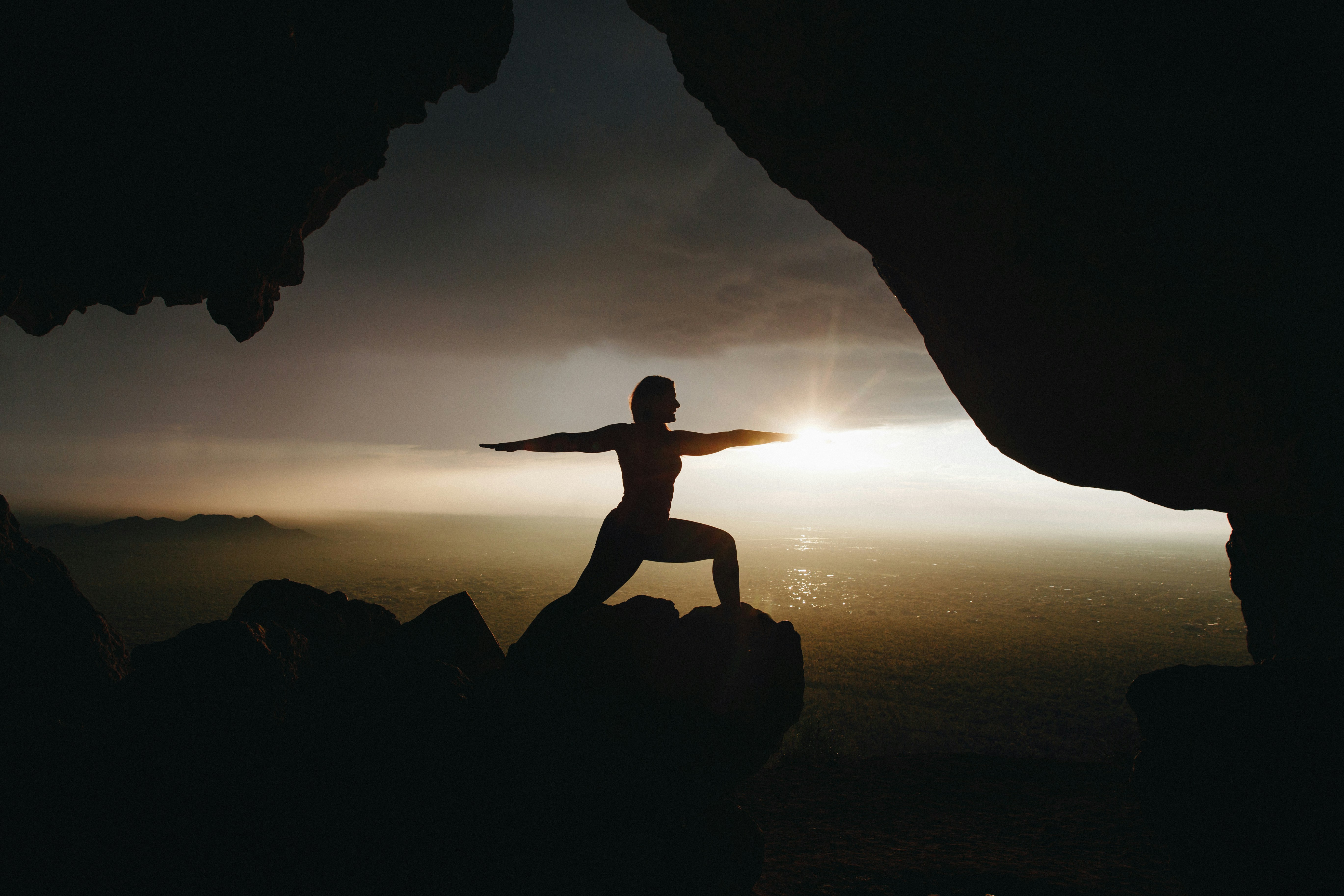 Yoga warrior silhouette at sunset
